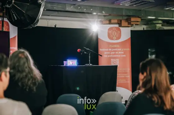 Scene du festival PodBXL avec micro et enseigne lumineuse ON AIR a Evere